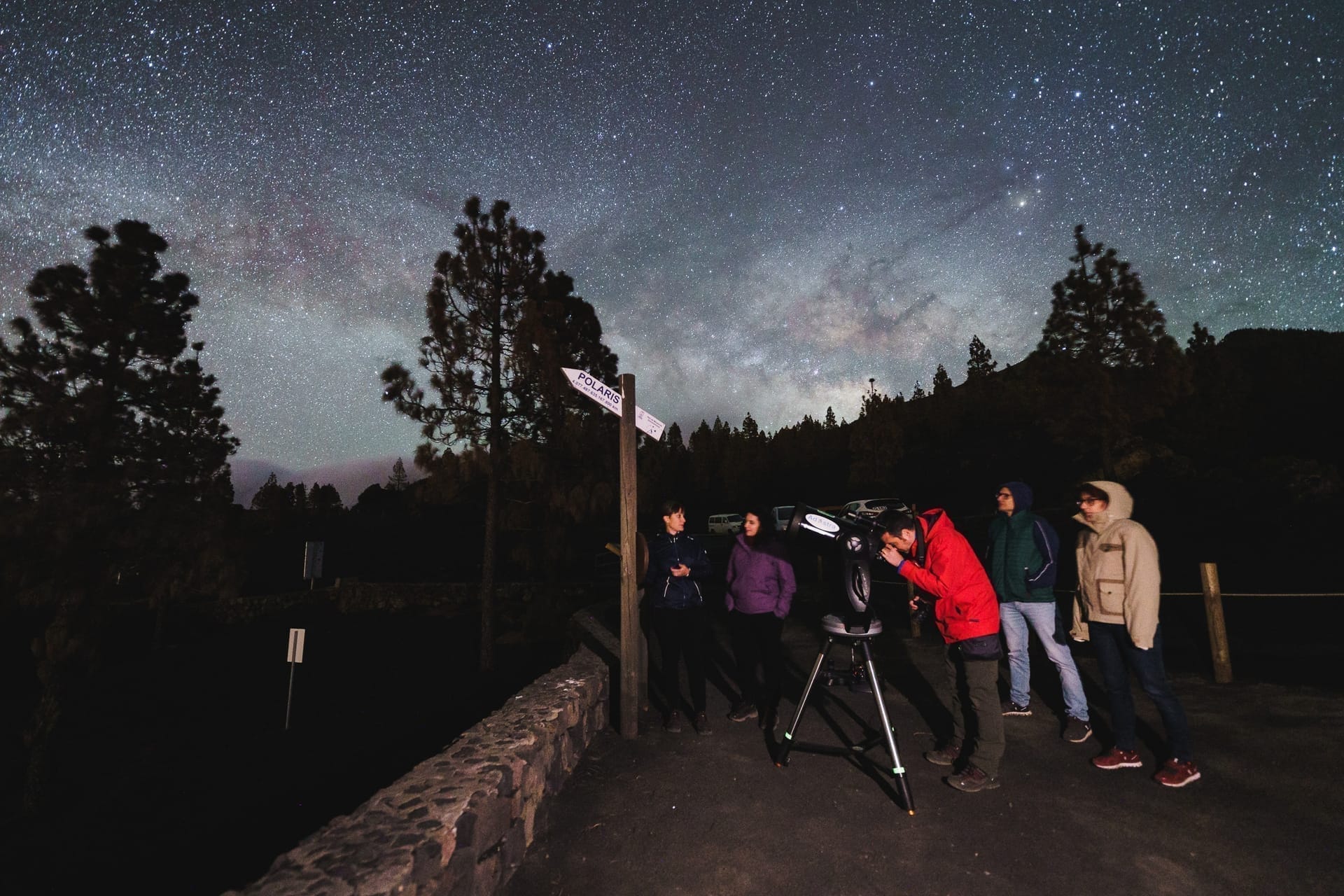 Grupo de personas observando el cielo nocturno en un mirador astronómico de La Palma